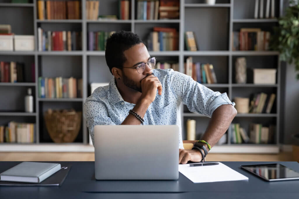 Black man answers UX survey, looking away in deep thought